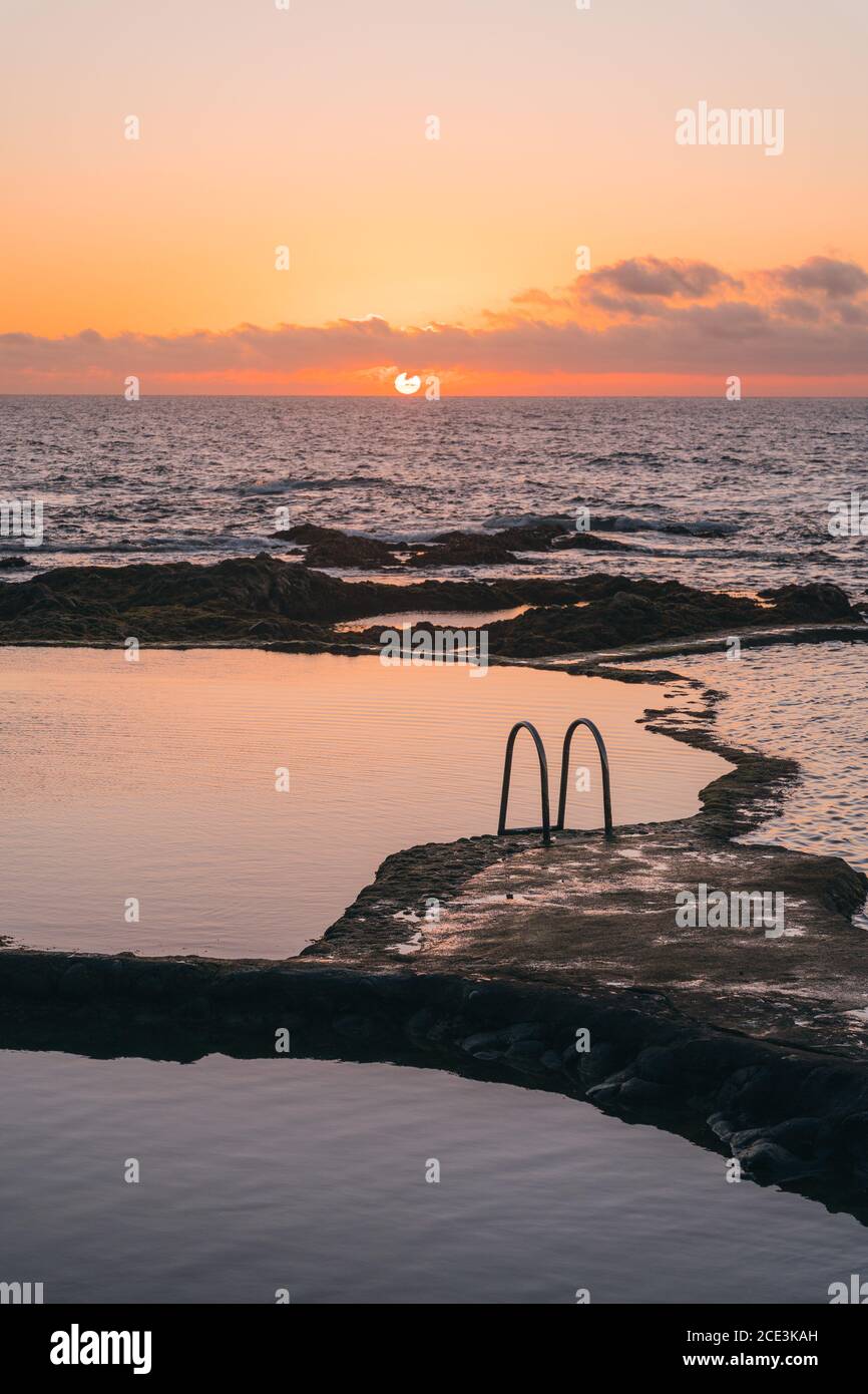 Beautiful natural pools with calmed waters at sunset. Relaxing contemplative vibe. Vertical wide shot Stock Photo
