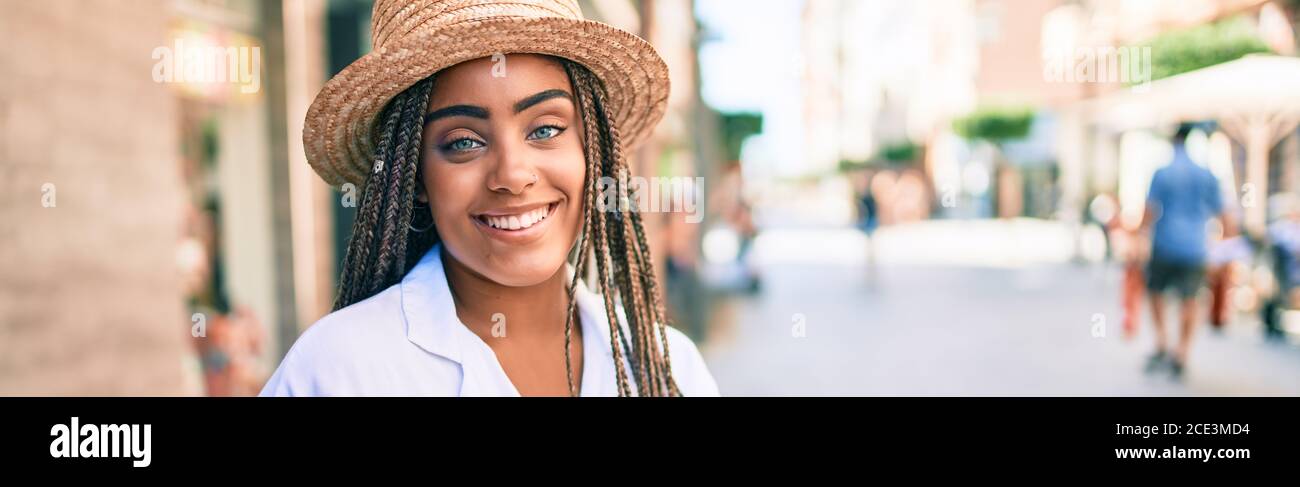 Young african american woman with braids smiling happy outdoors on a ...