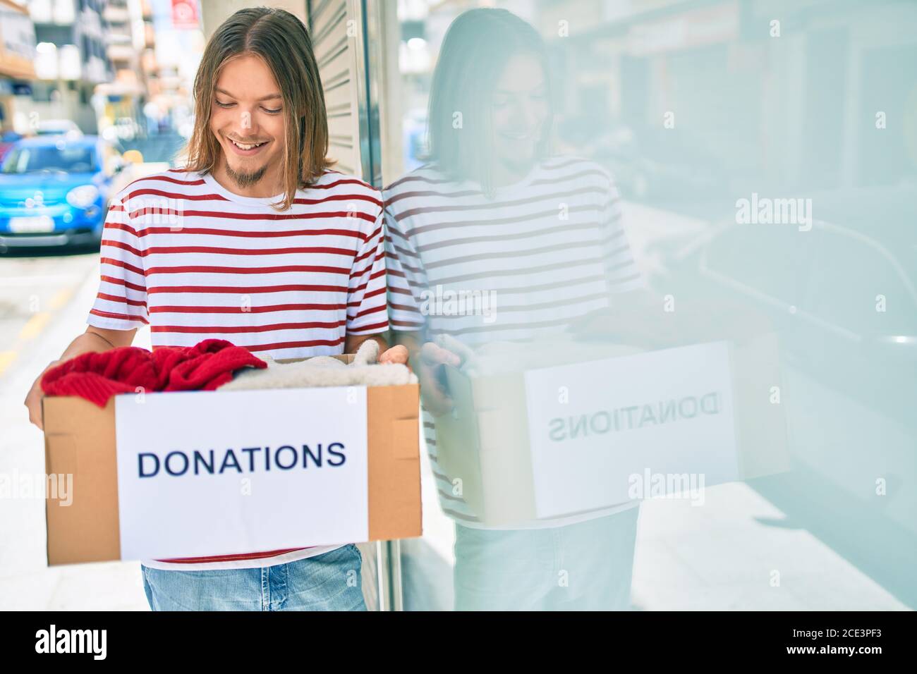 https://c8.alamy.com/comp/2CE3PF3/young-caucasian-man-with-blond-long-hair-and-beard-holding-cardboard-box-with-clothes-from-donations-2CE3PF3.jpg