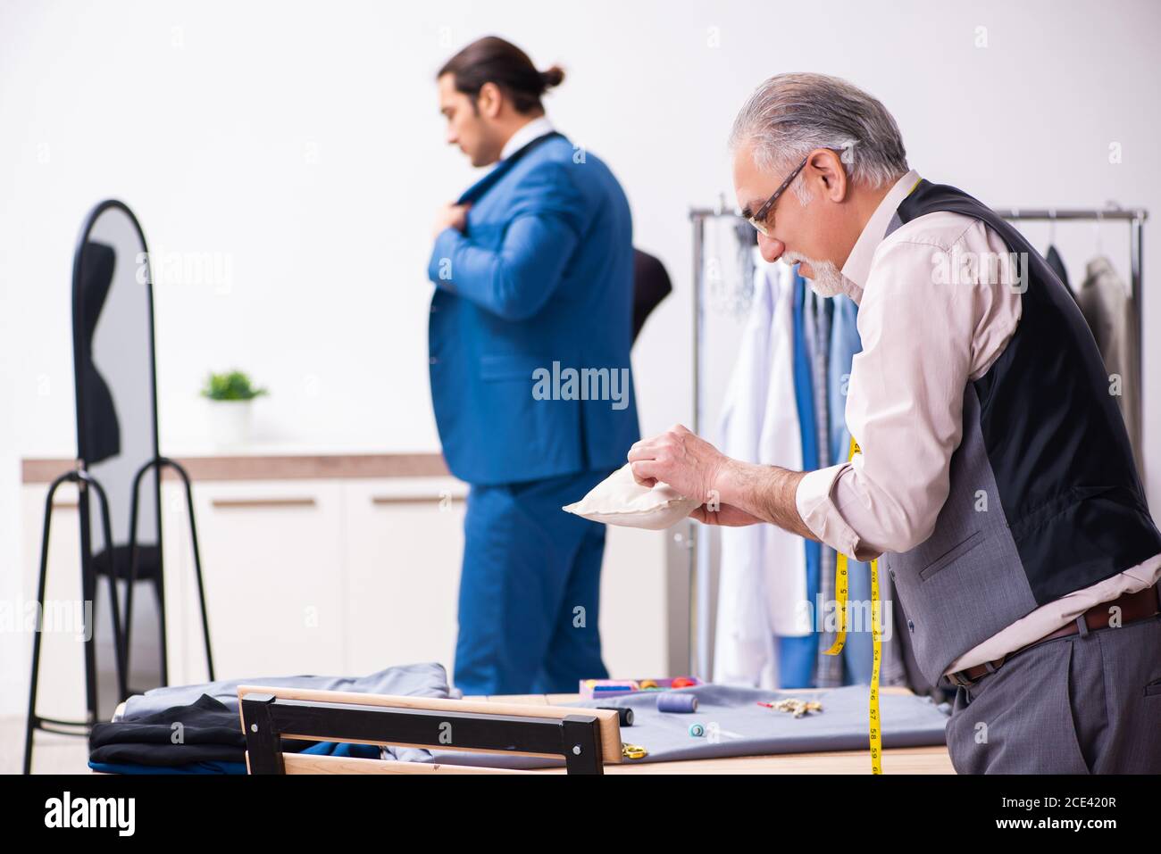 Young businessman visiting old tailor Stock Photo