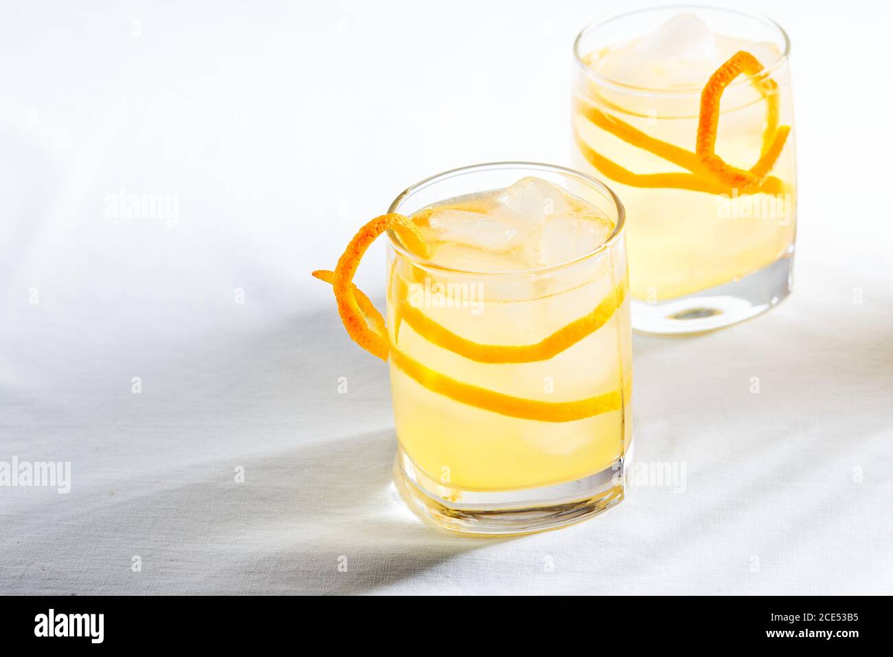 Cool refreshing alcohol cocktail decorated with orange zest Stock Photo