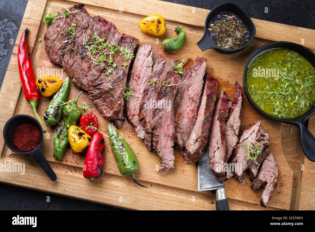 Modern design barbecue dry aged wagyu bavette de flanchet steak with chili  and chimichurri sauce as top view on a wooden cutting Stock Photo - Alamy