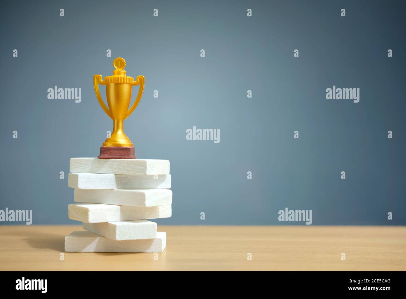 Golden trophy standing on white podium Stock Photo - Alamy