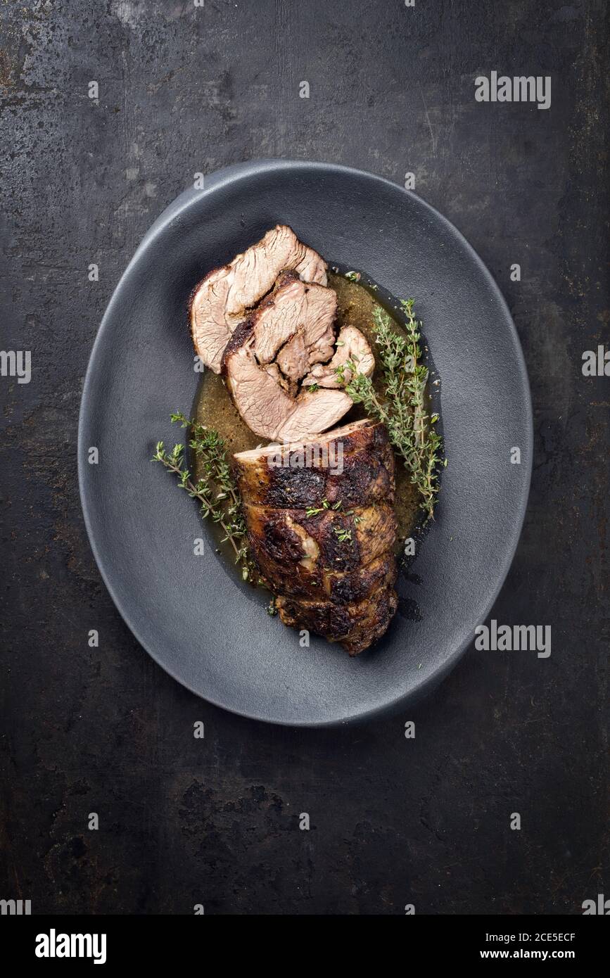 Barbecue marinated Greek lamb roast with herbs in gravy sauce as top