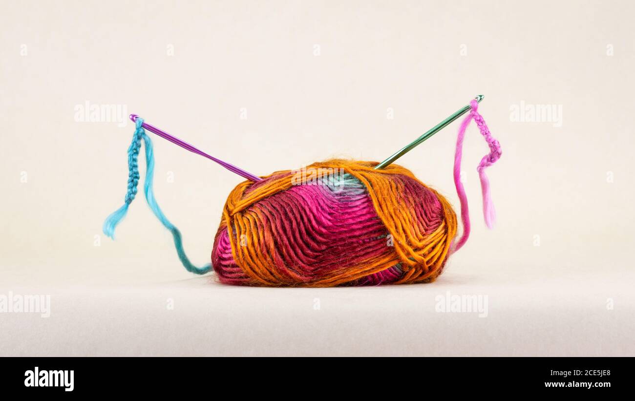 Colourful single ball of wool with crochet hooks and thread, Stock Photo