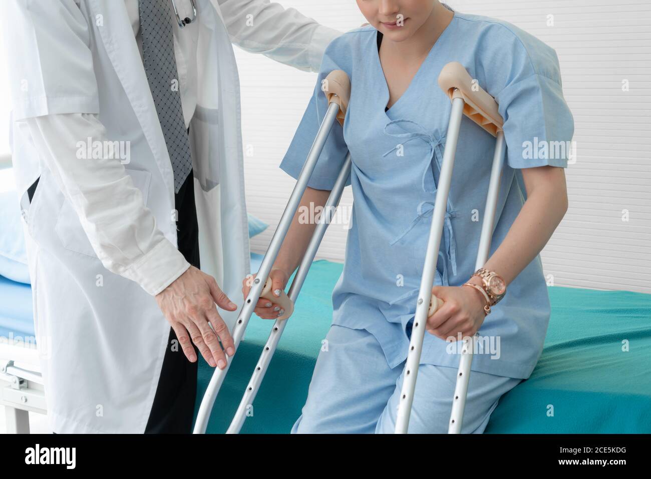 Doctor takes care of patient in crutch at hospital Stock Photo Alamy