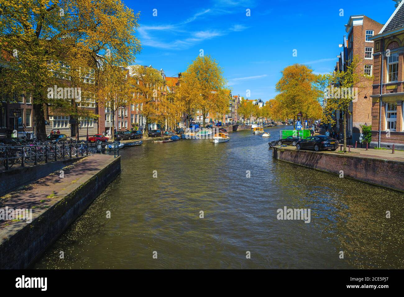 Cozy streets and walkways on the shore of the water canal with moored boats. Autumn cityscape with traditional buildings in Amsterdam, Netherlands, Eu Stock Photo