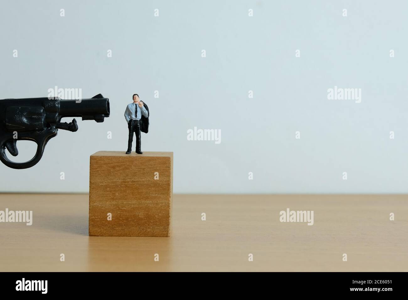 Miniature people concept - businessman standing on wooden block, thinking to death for debt solution Stock Photo