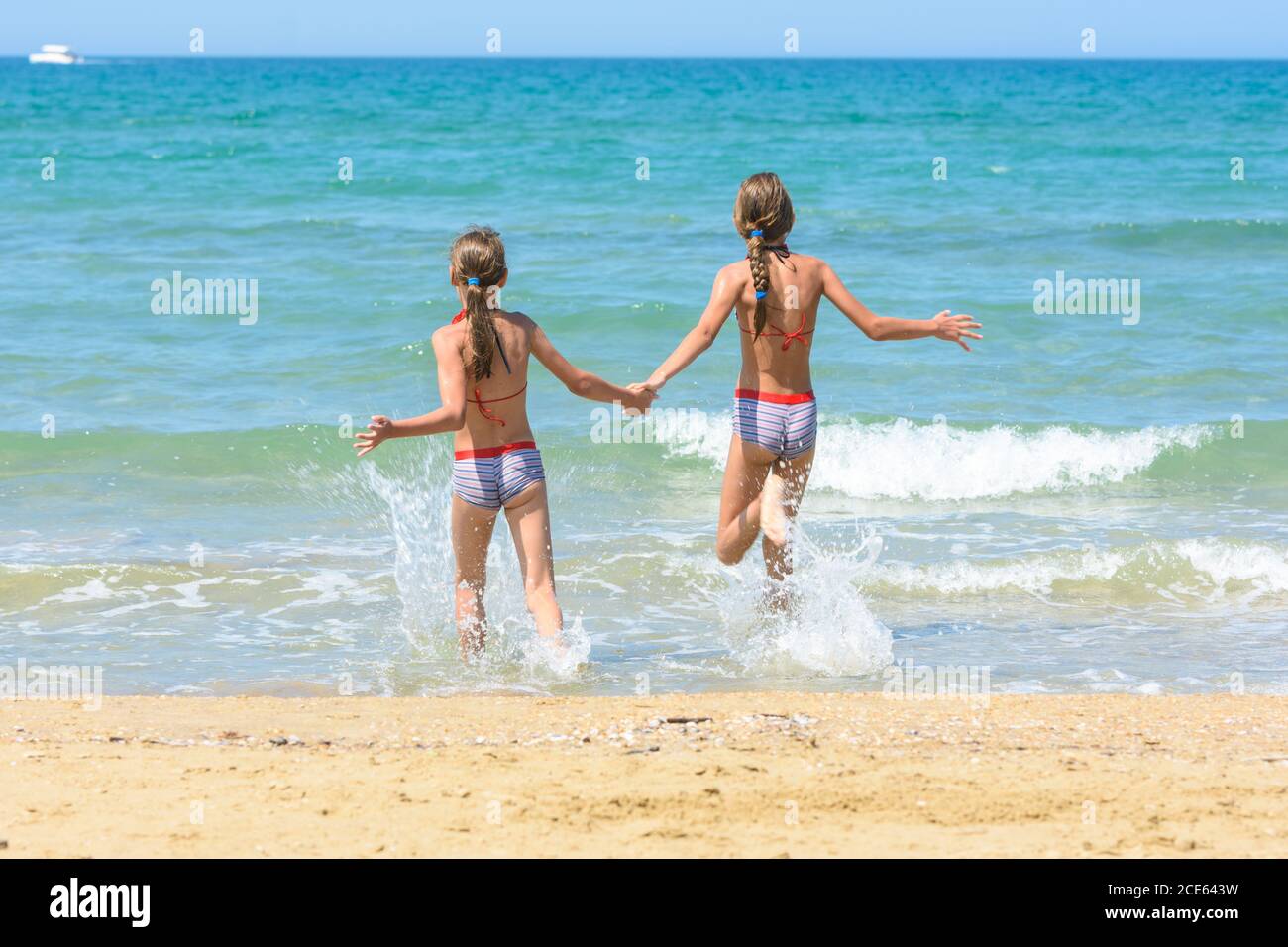 Children holding hands run swimming in the sea Stock Photo