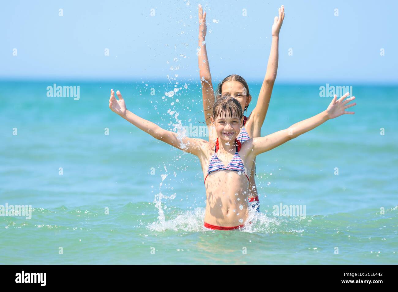 Two girls stood up for each other and joyfully raised their hands up. Stock Photo