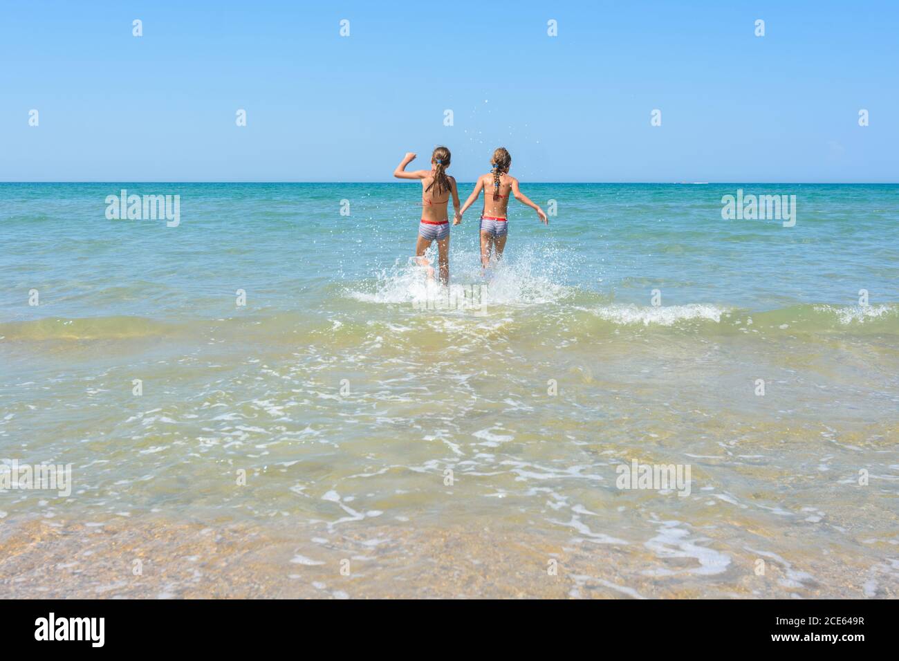 Girls run in the water swimming in shallow water Stock Photo
