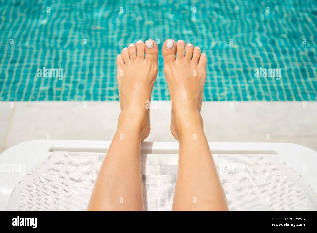 Woman relaxing by the pool Stock Photo