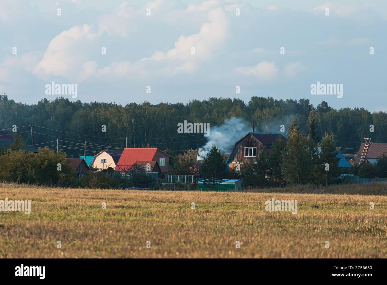 Traditional wooden houses at sunny day in the countryside with field ...