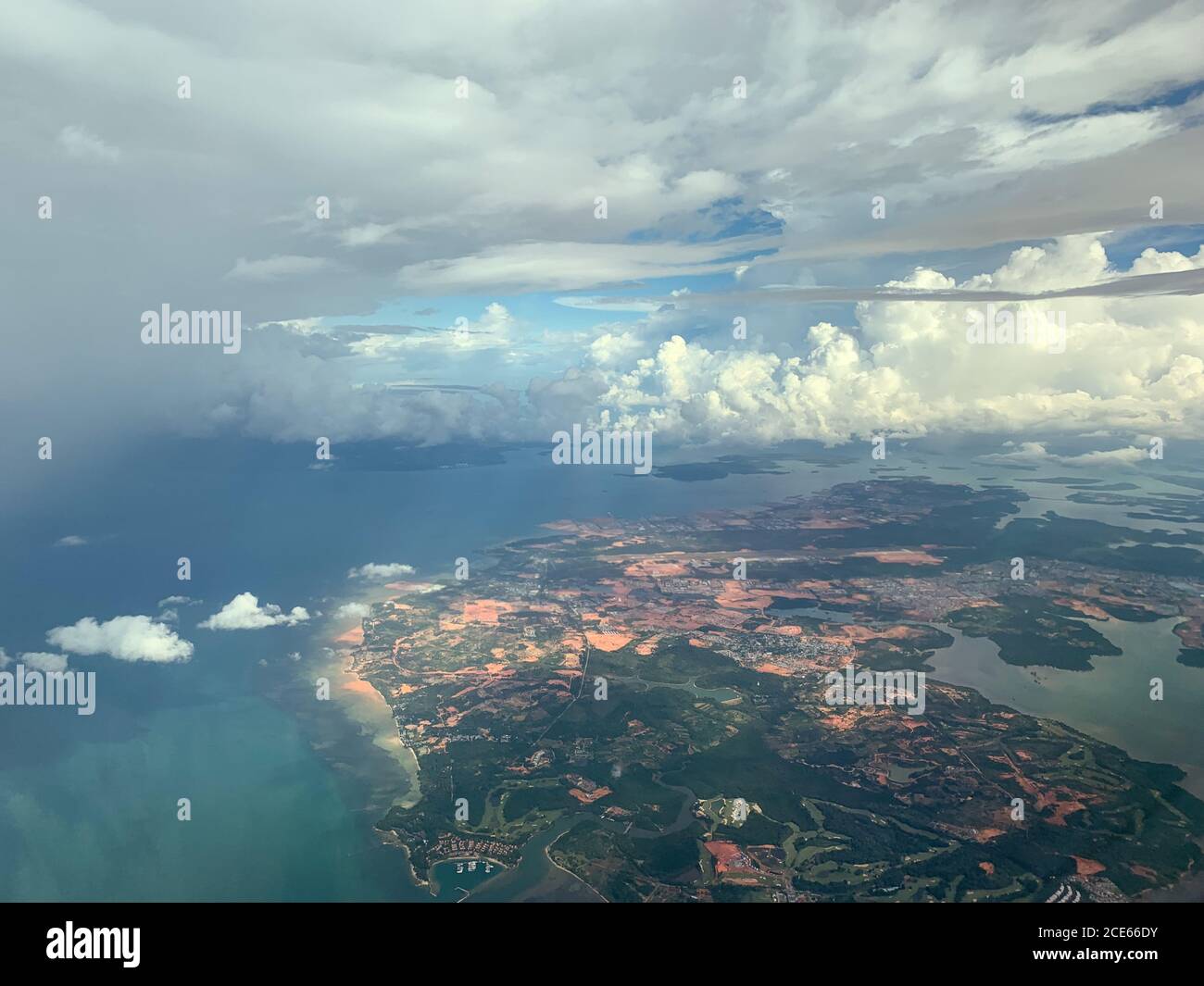 Wing of an airplane flying above the ocean. The view from an airplane window. Stock Photo
