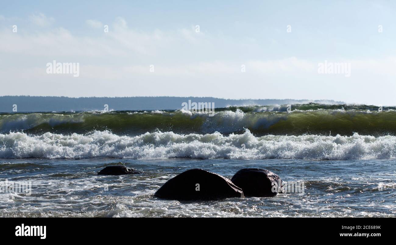 Breaking waves in a stormy sea. The sea hit the rocky shore Stock Photo ...