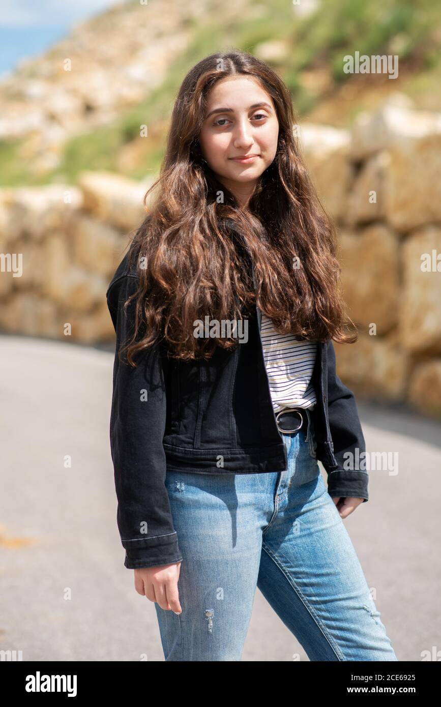 Beautiful teenage girl looking at camera smiling outdoors Stock Photo