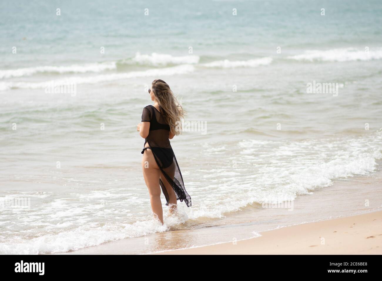 Woman standing on the beach Stock Photo