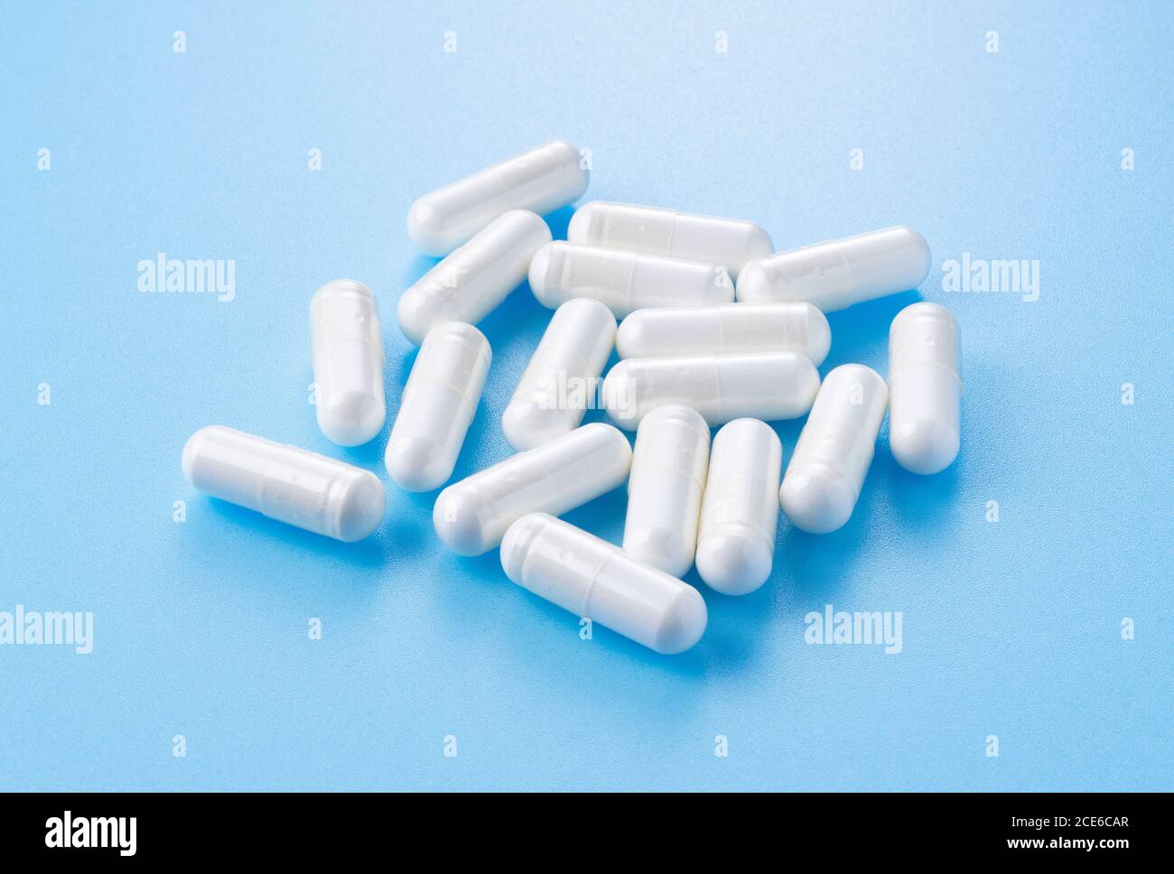 White capsules placed on blue background Stock Photo