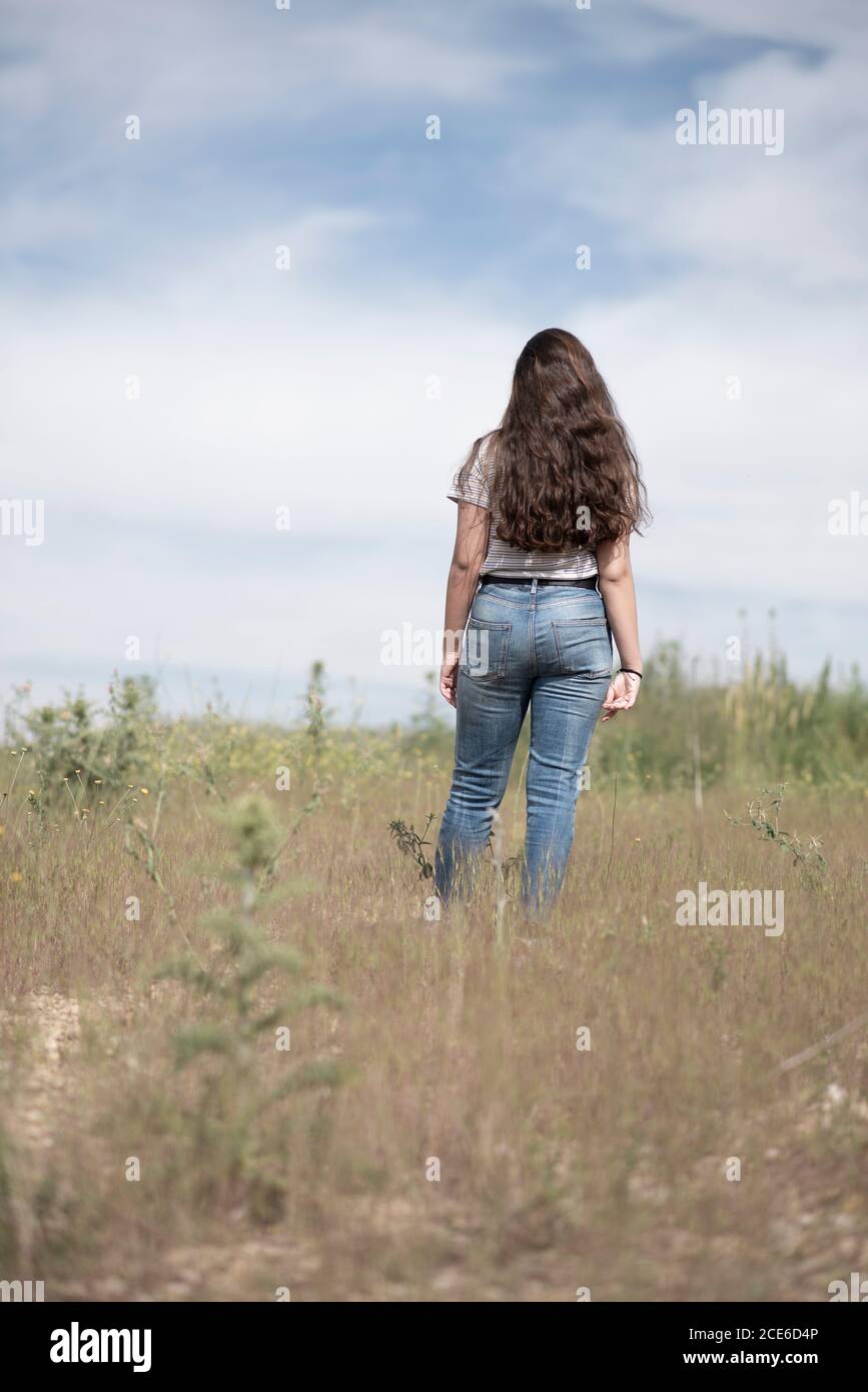 Rear view of teenage girl walking in field Stock Photo - Alamy