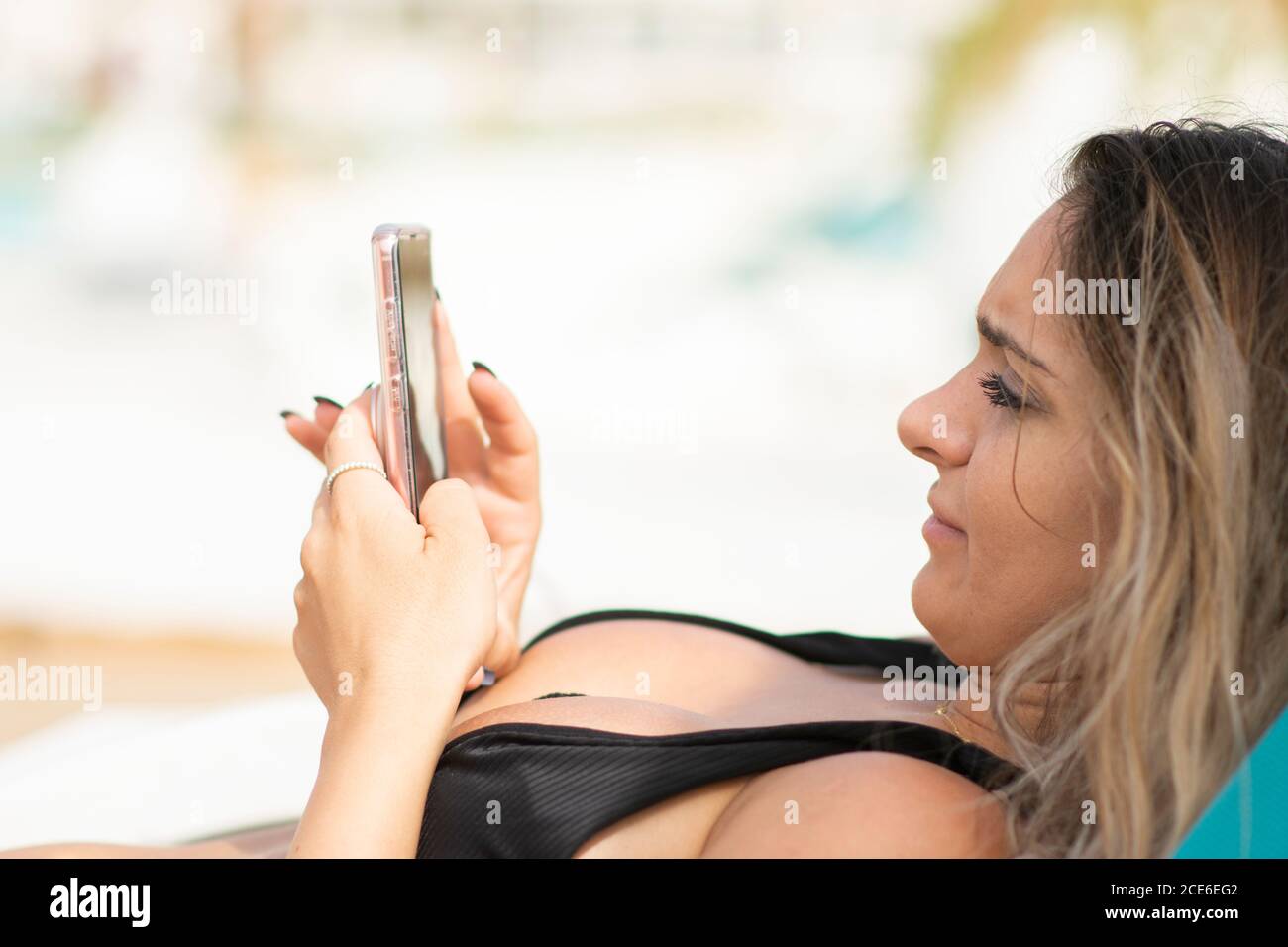 Woman texting on smart phone on the beach Stock Photo