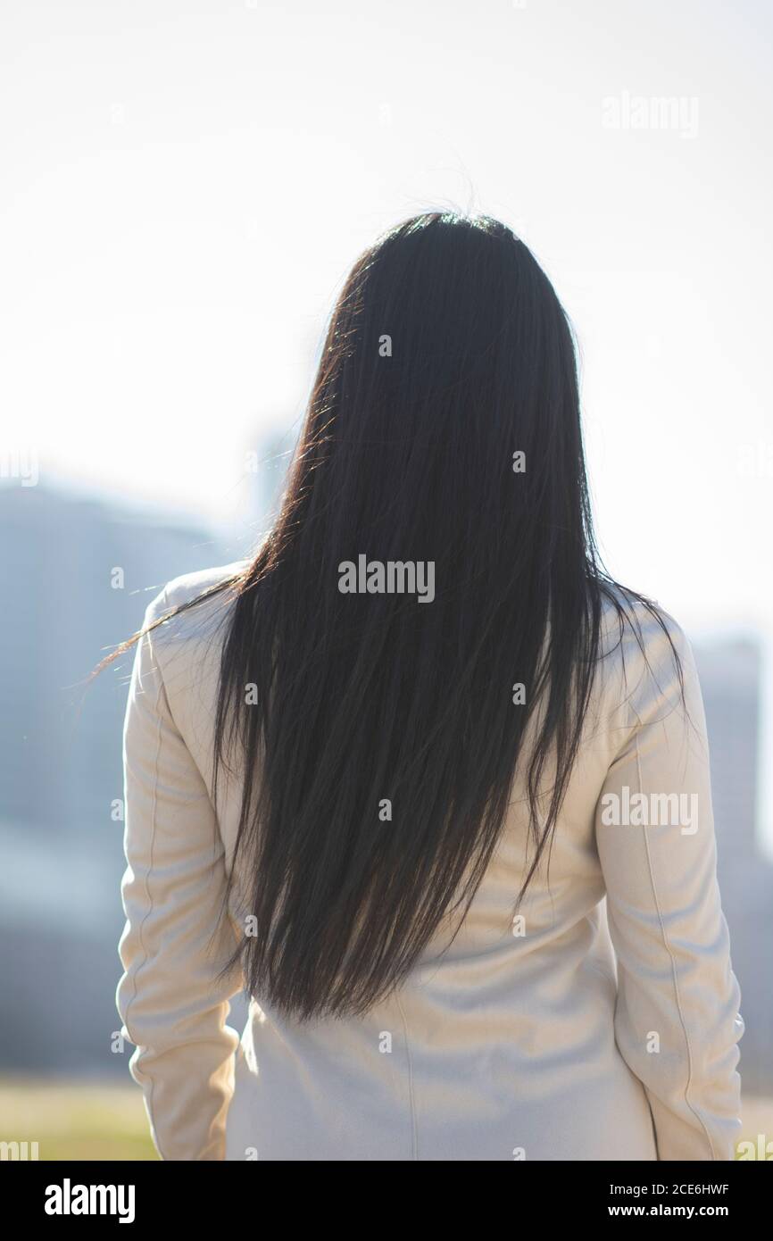 Rear view of woman with long hair standing outdoors Stock Photo - Alamy