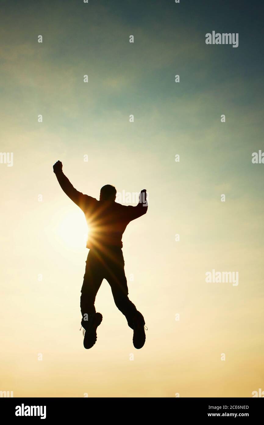 Flying man in air. Man falling down on colorful sky background. Vintage Style Stock Photo