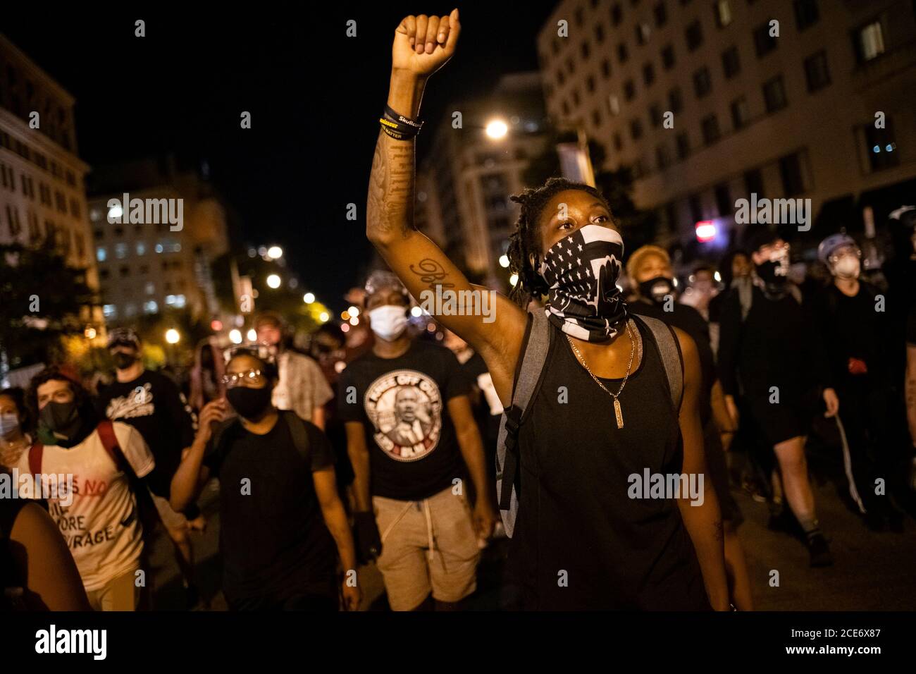 Washington, USA. 30th Aug, 2020. A protester raises a fist while marching for racial justice in downtown Washington, DC, on August 30, 2020 amid the coronavirus pandemic. The night after police violently pushed crowds out of Black Lives Matter Plaza, nonviolent protesters again gathered there before marching, and upon returning to the plaza to rally police in riot gear aggressively pushed them out causing injuries. (Graeme Sloan/Sipa USA) Credit: Sipa USA/Alamy Live News Stock Photo