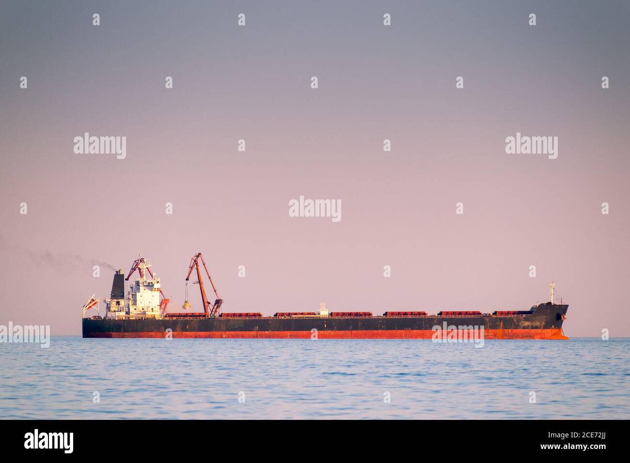 Bulk carrier ship at sea in calm weather on sunset Stock Photo