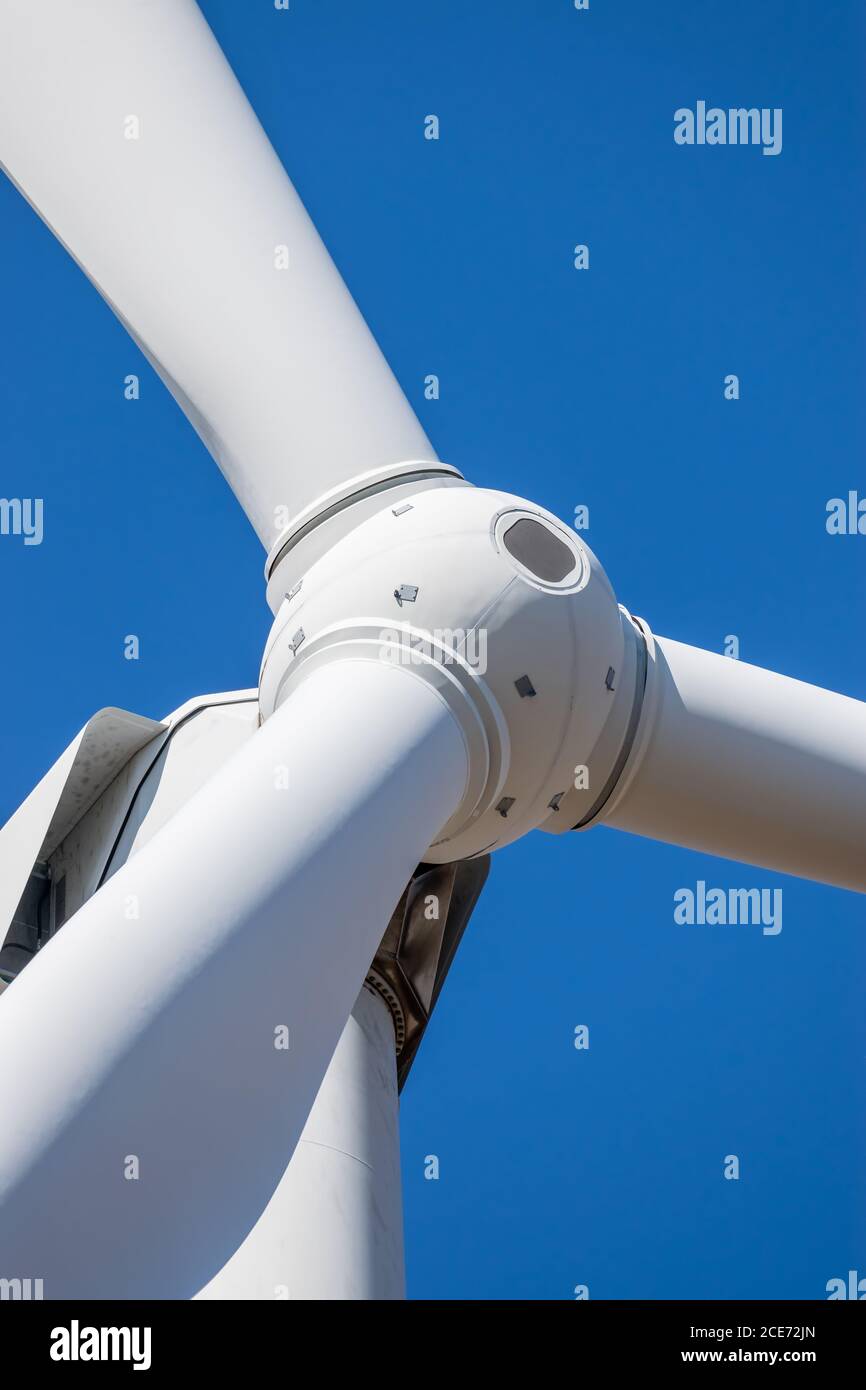 Wind turbine head rotor closeup against blue sky background Stock Photo