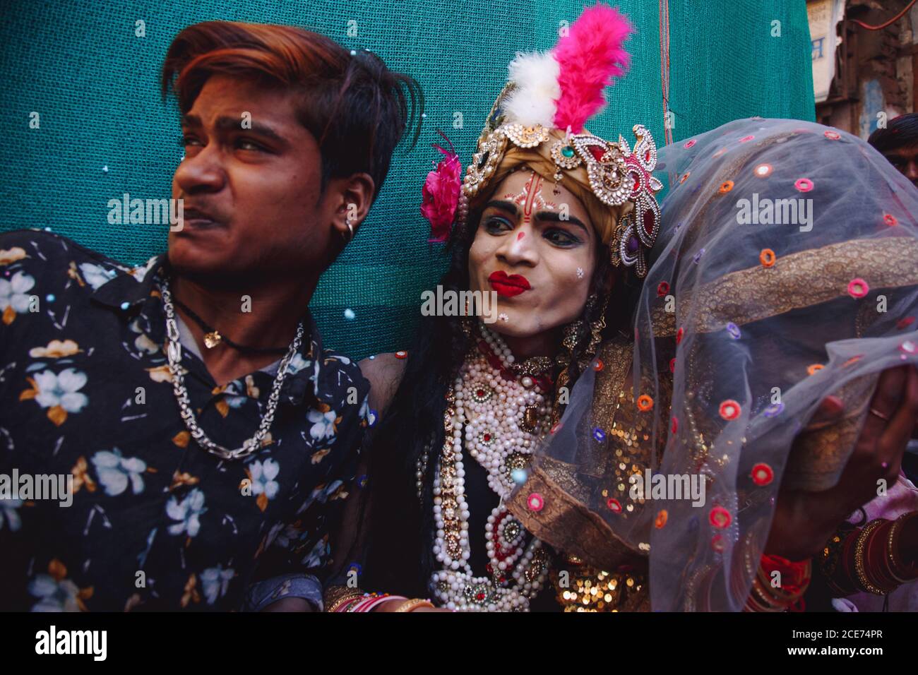 India - March 9, 2020: Ethnic people in funky wear looking away during festive event on street Stock Photo