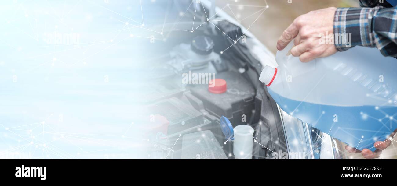 Hands of mechanic pouring blue windshield washer fluid in a car; panoramic banner Stock Photo