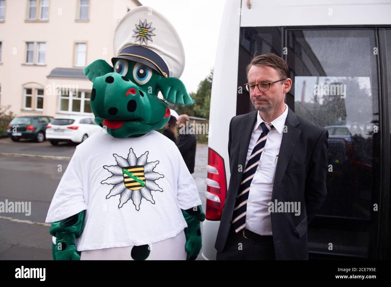 Freital, Germany. 31st Aug, 2020. The police mascot 'Poldi' is standing next to Roland Wöller (CDU), Minister of the Interior of Saxony, during a press meeting on the road safety campaign 'School has started'. After six weeks of summer vacation, Saxony's students are returning to their schools. Credit: Sebastian Kahnert/dpa-Zentralbild/dpa/Alamy Live News Stock Photo