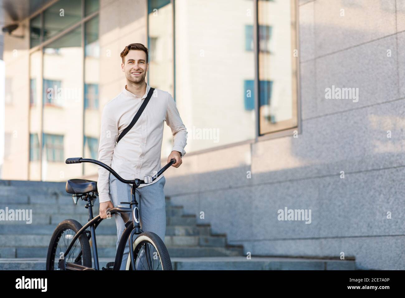 Convenient transport in city. Businessman walking down stairs with bicycle Stock Photo