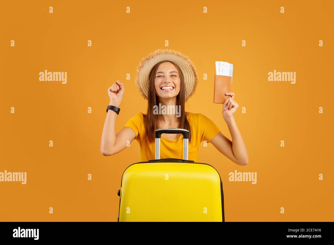 Excited girl with luggage holding passport and flight tickets Stock Photo