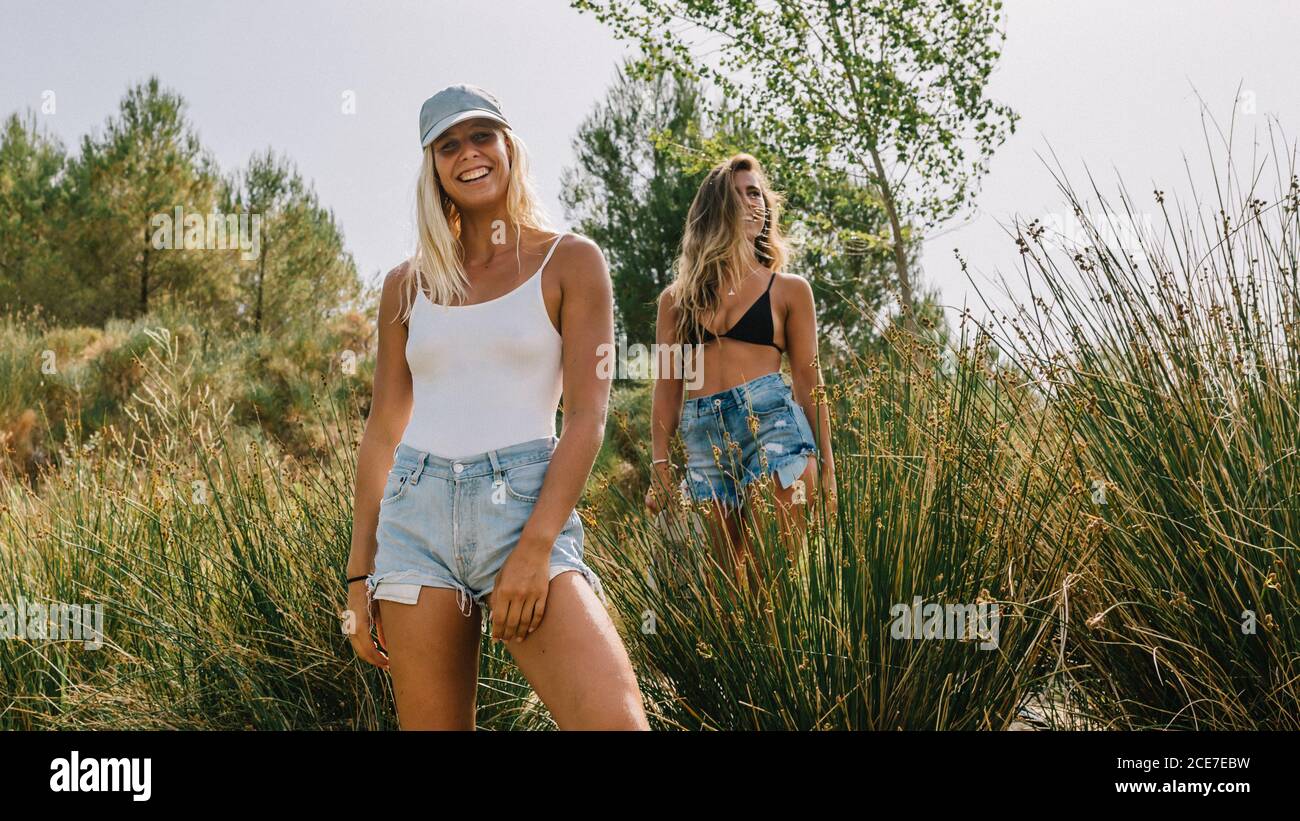 Cheerful female friends in summer clothes enjoying summer vacation and looking at camera Stock Photo