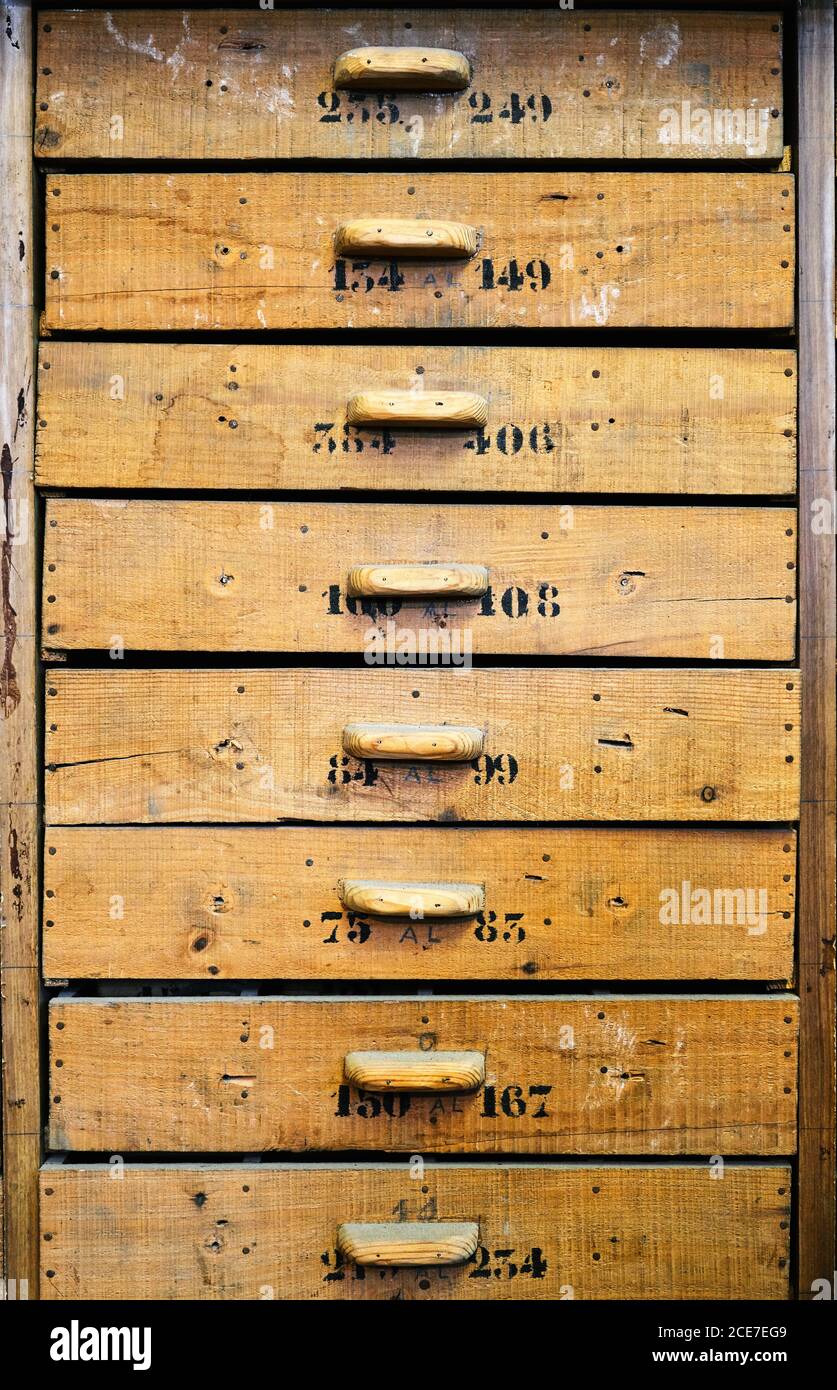 Archive Representing Identical Light Brown Wooden Drawers With Rectangular Handles And Numbers On Uneven Surface With Spots And Words In Workshop Stock Photo Alamy