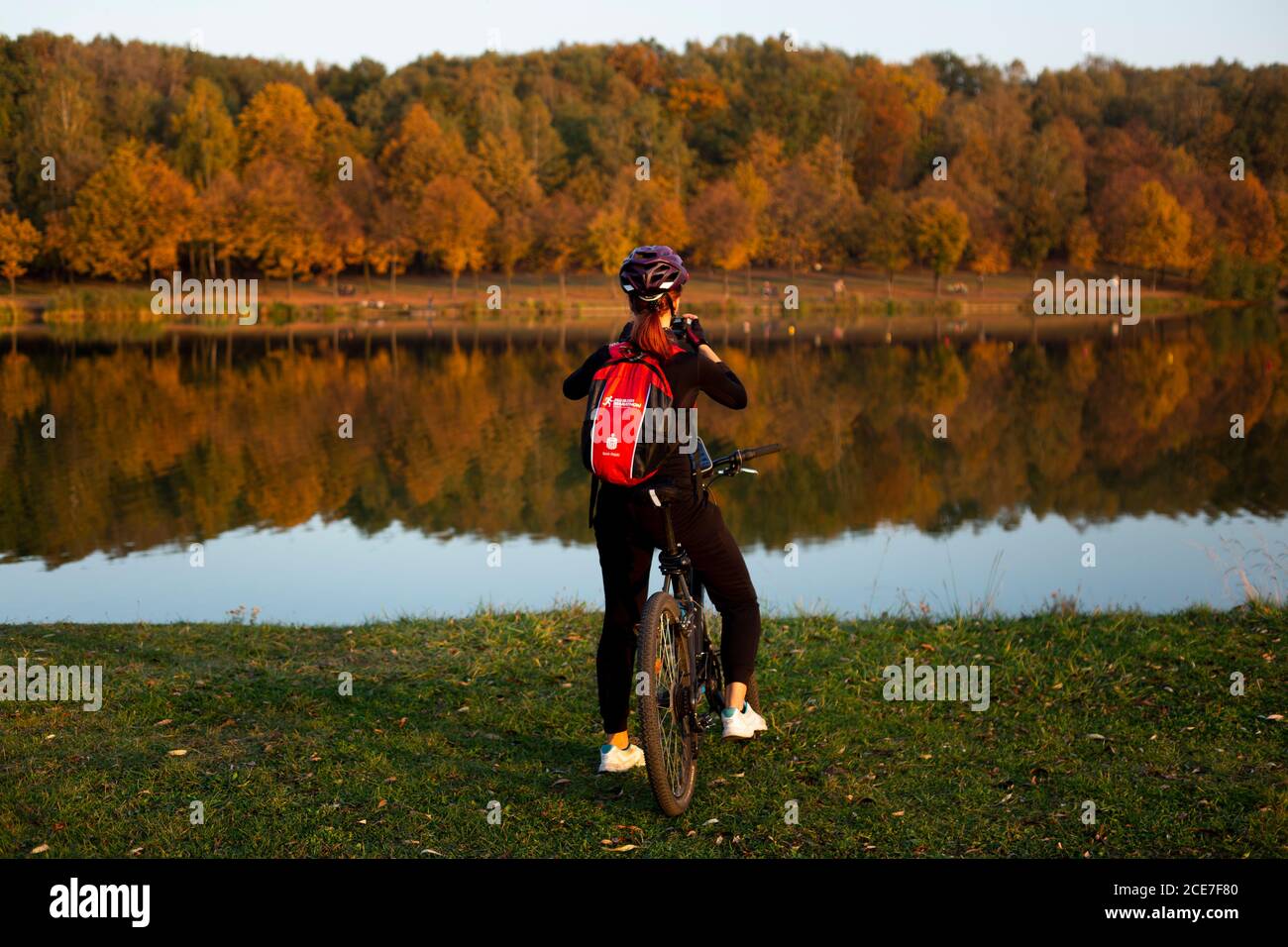 Katowice, Poland. 12th October, 2018. A woman is seen on a bicyle near Kajakowy lake at the Valley of Three Ponds in Katowice. Stock Photo