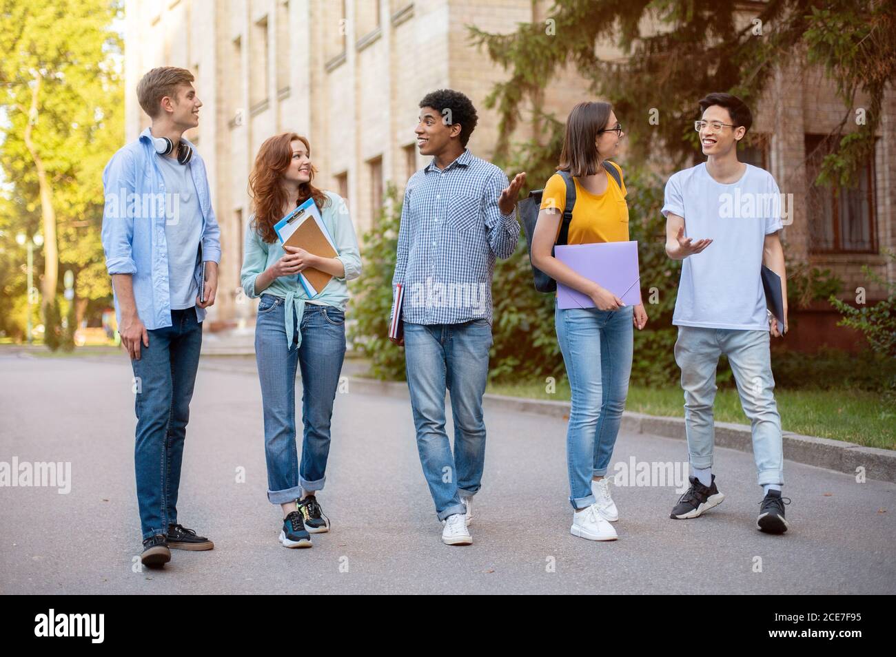 Group Of Multicultural First-Year Students Walking Near University Building Outside Stock Photo