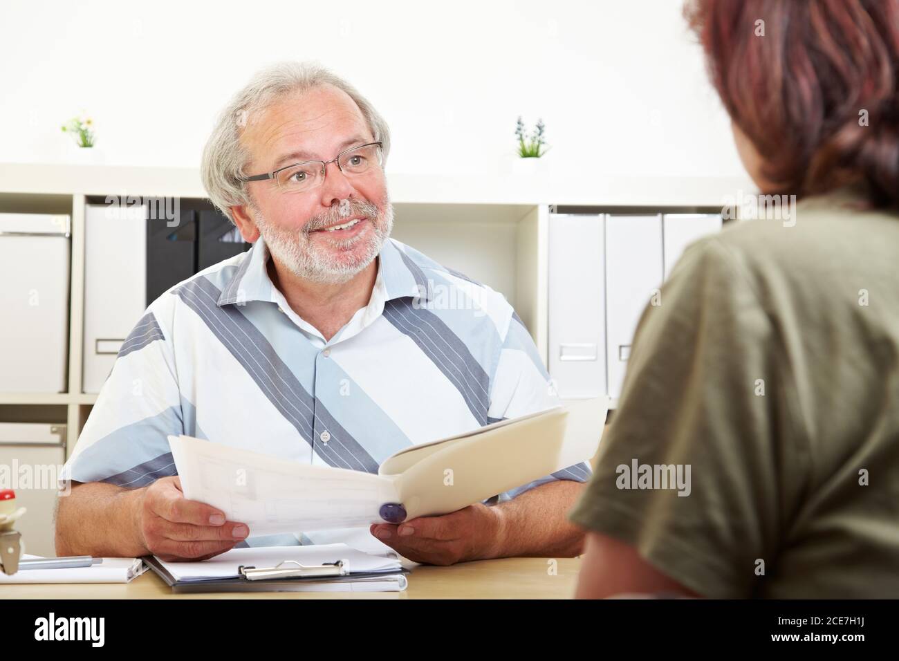 Friendly advisor with file in a customer meeting Stock Photo