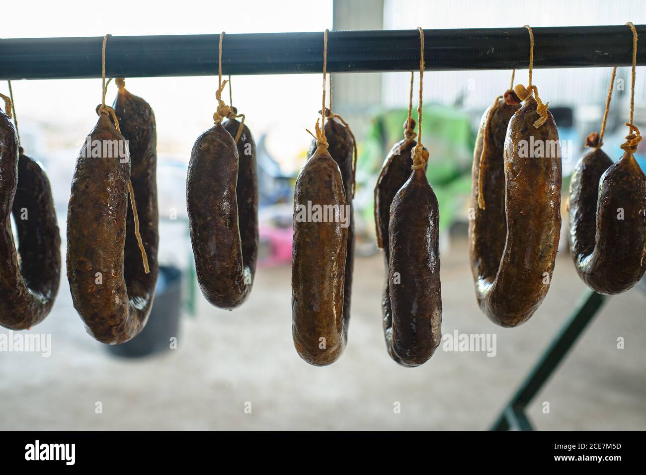 Selection of fresh homemade traditional Spanish chorizo sausages hanging on rack outside of
