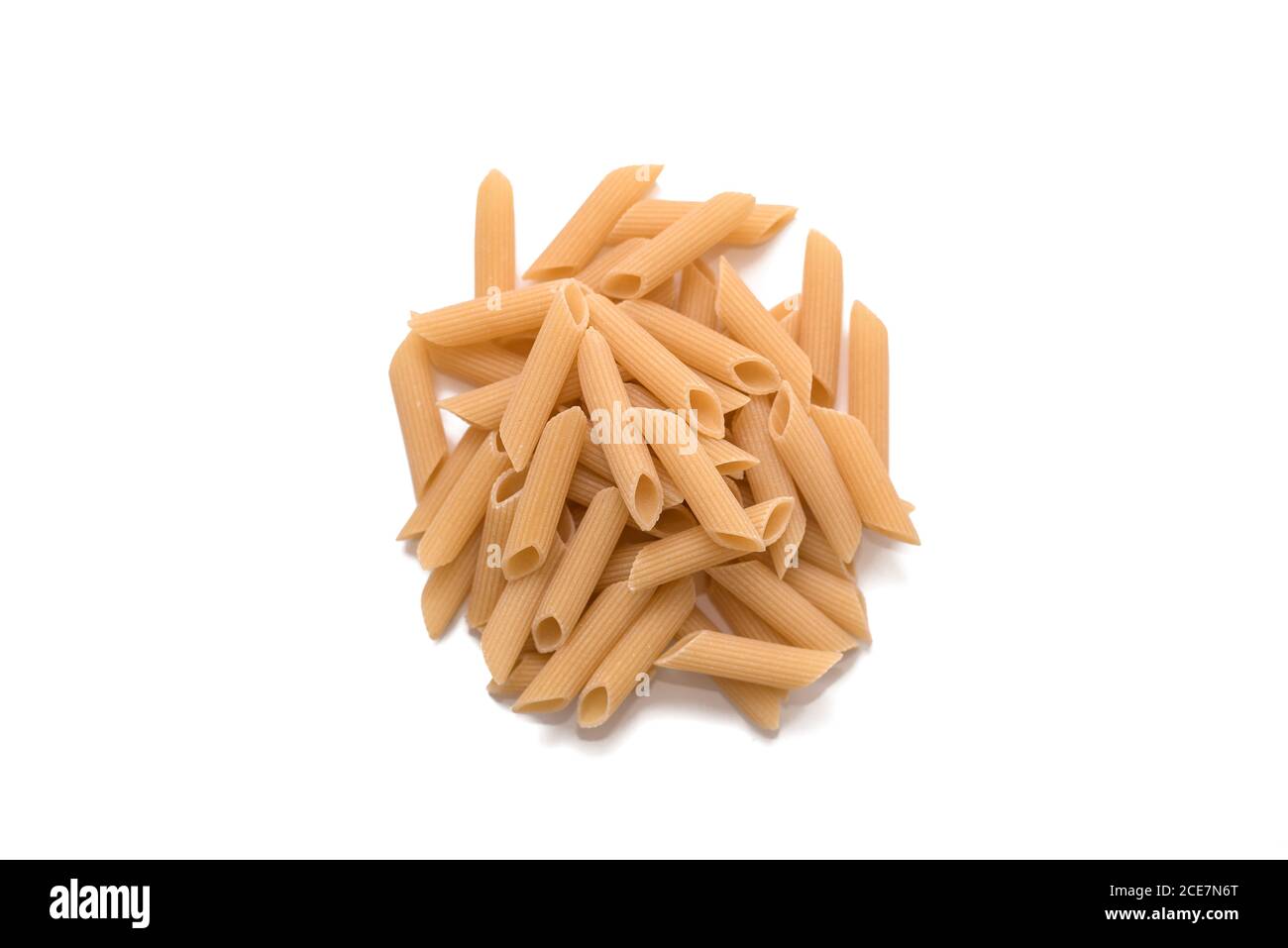 Close-up of uncooked organic penne rigate pasta on white background. Slow carbs concept. Top view Stock Photo