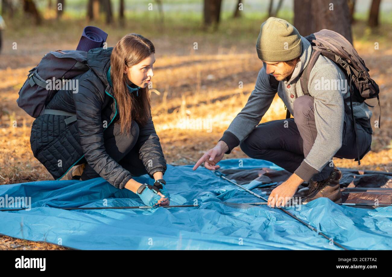 Couple of hikers pitching the tent before a sunset Stock Photo