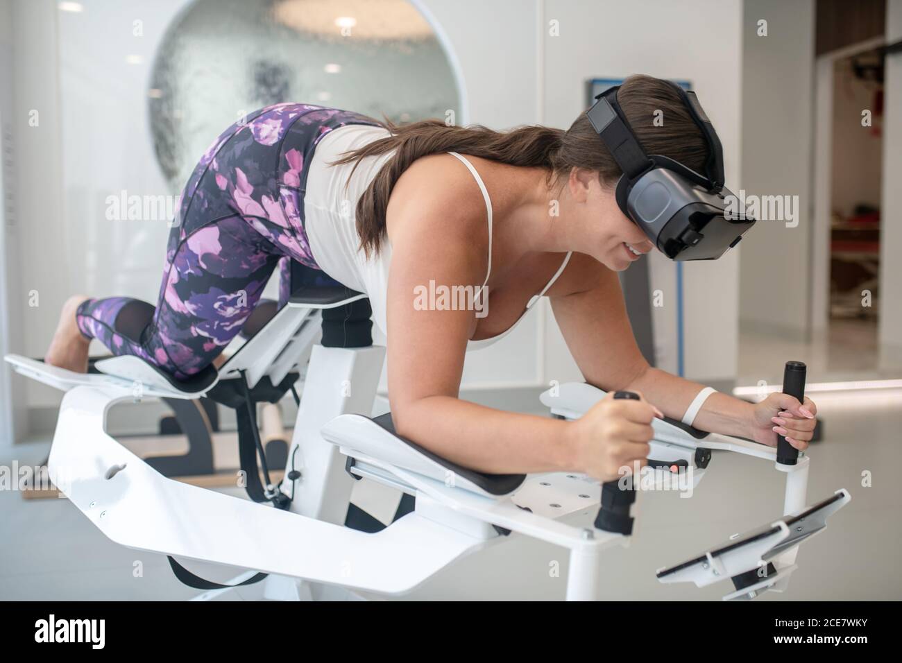 Woman using VR simulation while doing sports Stock Photo