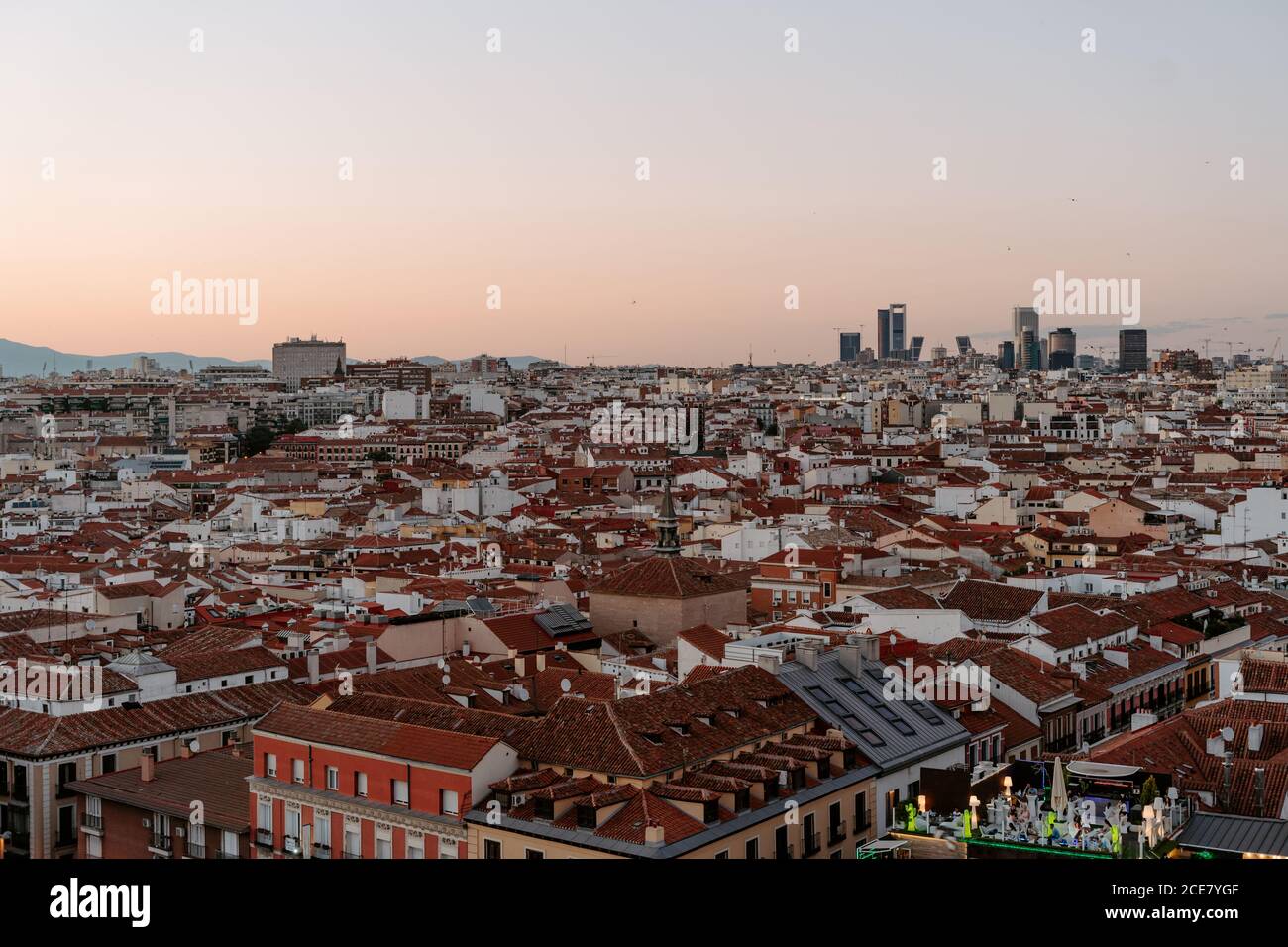From above amazing view of typical residential densely built up district of Madrid city with low rise houses with red roofs seen from rooftop during sunset in summer evening Stock Photo