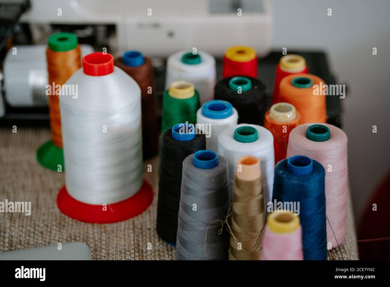 High angle of various colorful cotton threads on spools arranged on ...