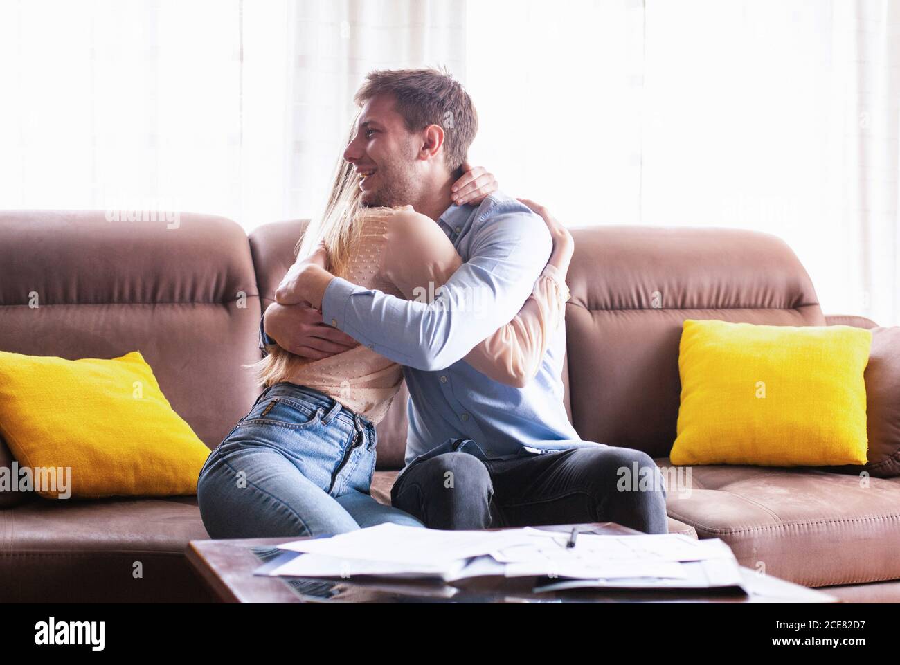Happy millennial couple hugging after signing real estate purchase agreement indoors Stock Photo