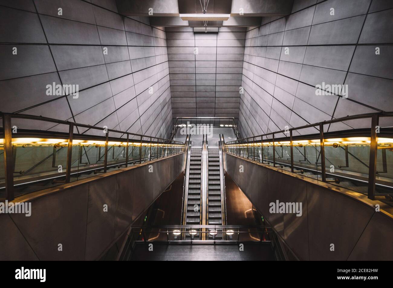 Interior of empty underground with contemporary narrow moving staircase ...