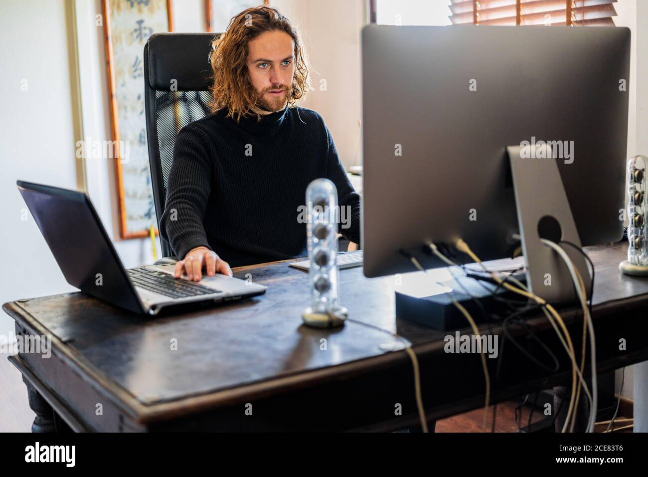 Handsome man working at desktop computer at home Stock Photo