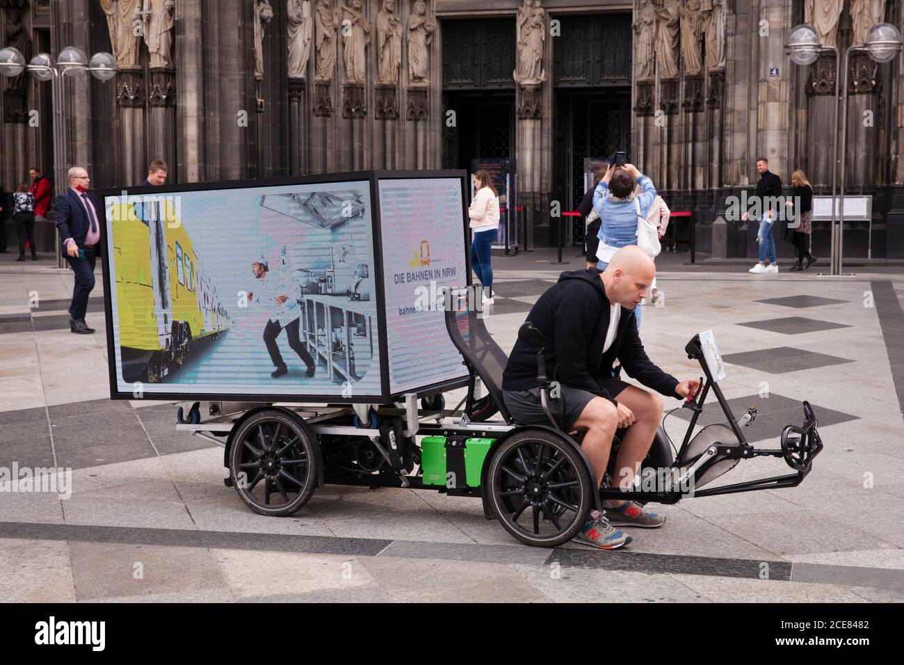 electric bike (trike) with digital 360 degree LED screen for mobile outdoor advertising in front of the cathedral, Cologne, Germany.  elektrisches Bik Stock Photo