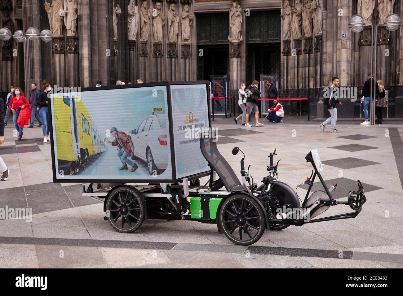 electric bike (trike) with digital 360 degree LED screen for mobile outdoor advertising in front of the cathedral, Cologne, Germany.  elektrisches Bik Stock Photo